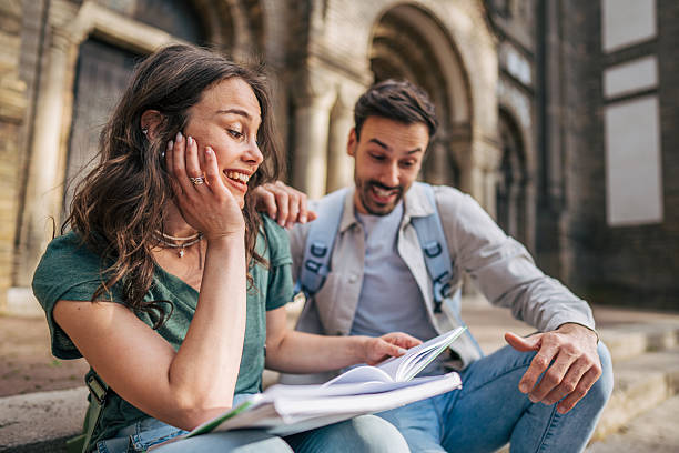 istock Students sharing a funny moment while studying together outdoors 2213464380