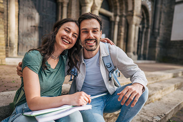 istock Happy students smiling and studying together in front of university 2213464560