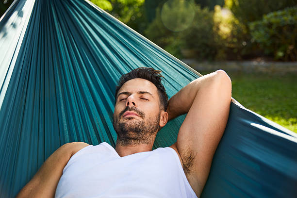 istock Adult man sleeping in hammock in backyard 2213464639