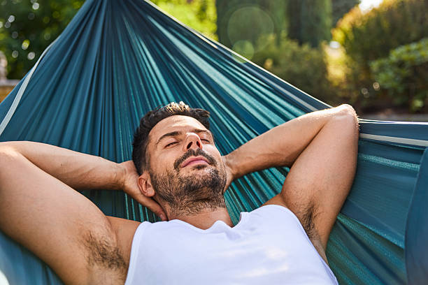 istock Close up of handsome man napping in hammock in the backyard 2213464760