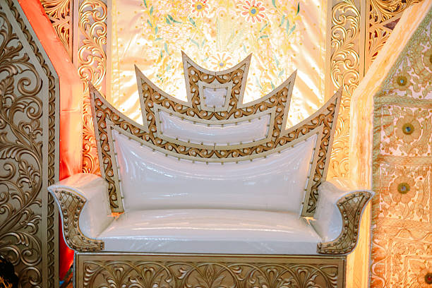 Close-up of an ornate throne with golden accents providing a regal backdrop for celebrations and events. A symbol of luxury and tradition