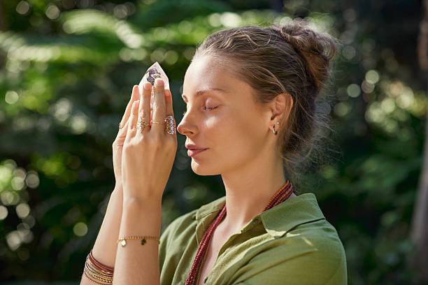 Woman meditating with clear quartz flame crystal