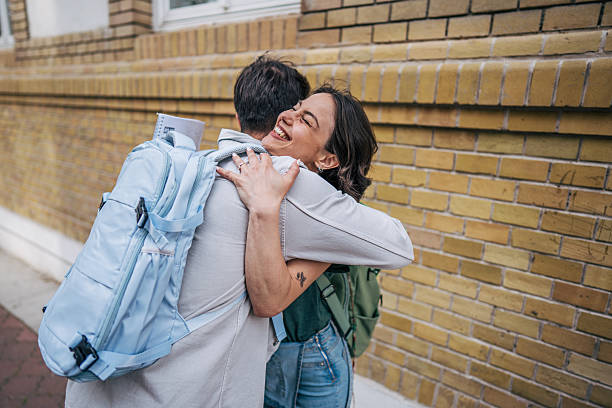 istock Two young students happily embracing each other outdoors 2213466407