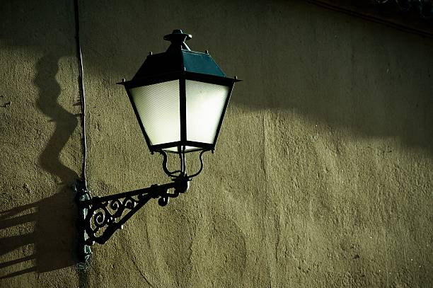 istock Antique lantern on aged wall at sunset 2213466425