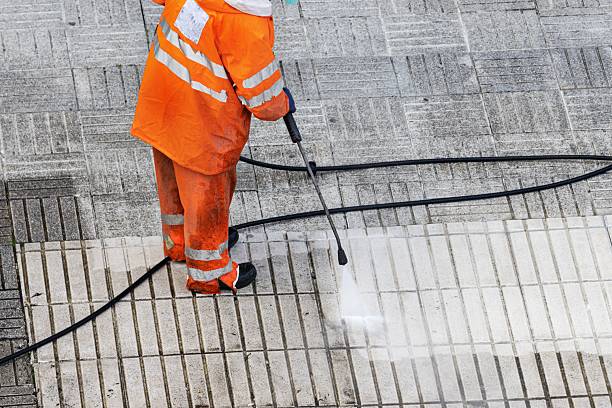 istock Worker cleaning a street sidewalk with high pressure water jet 2213468344