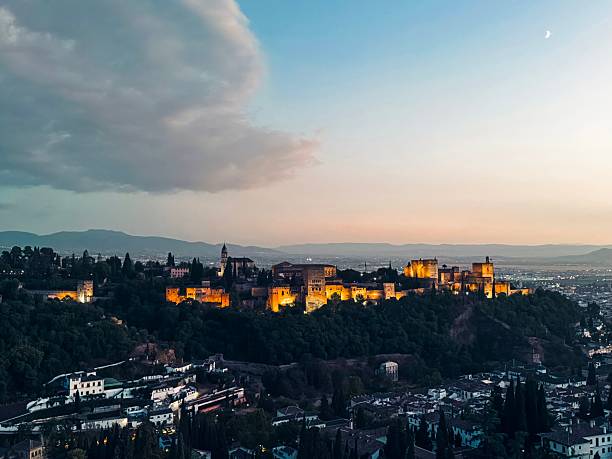 A stunning view of the Alhambra at dusk in Granada, Spain, with the illuminated fortress against a twilight sky.