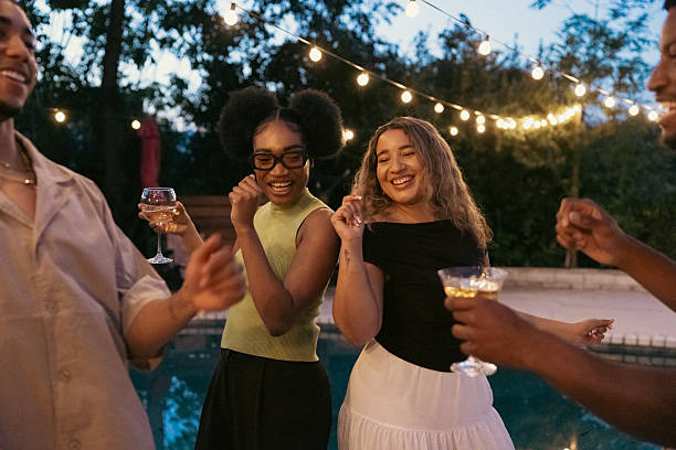 Friends dancing and having fun at after party on poolside