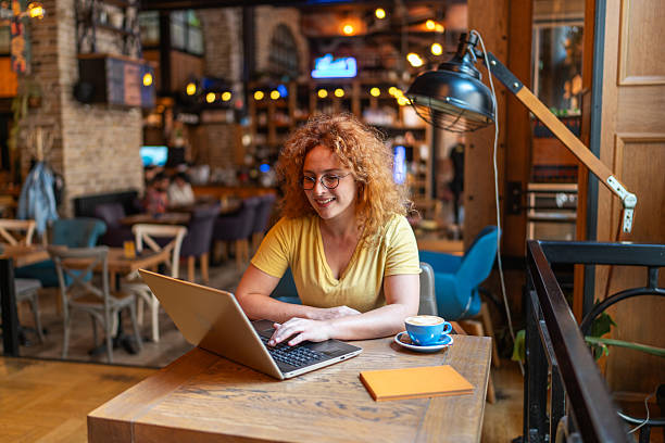 istock Young freelancer working on laptop in cozy cafe 2213469389