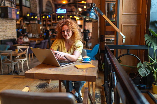 istock Freelancer working on laptop in cozy cafe enjoying coffee 2213469393