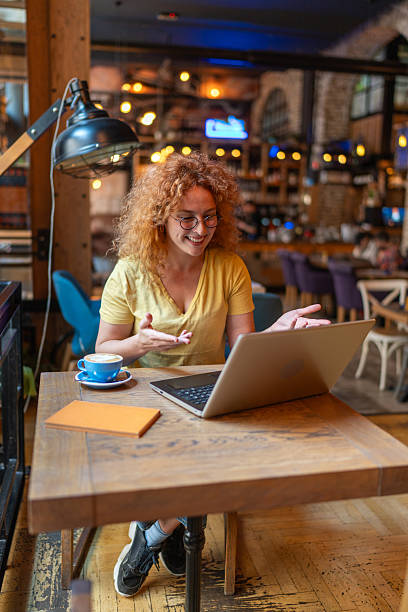 istock Freelancer woman video calling with laptop in a cafe 2213469446