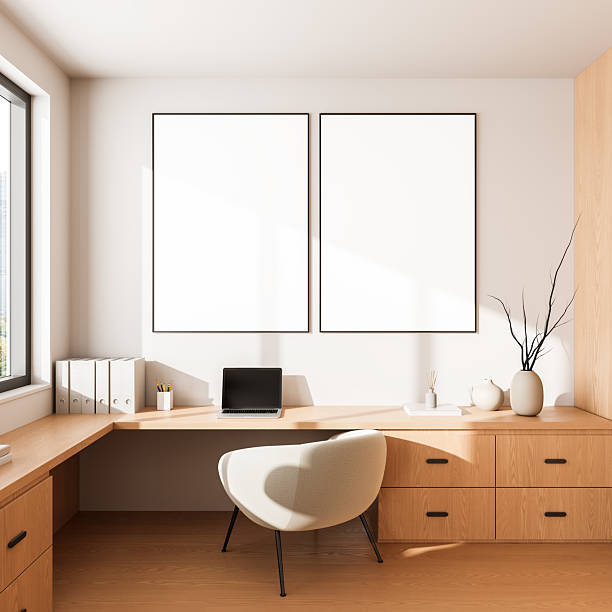 istock Modern home office interior with wooden desk and two large empty poster mockups on wall illuminated by natural light from window.. 3D Rendering 2213473609
