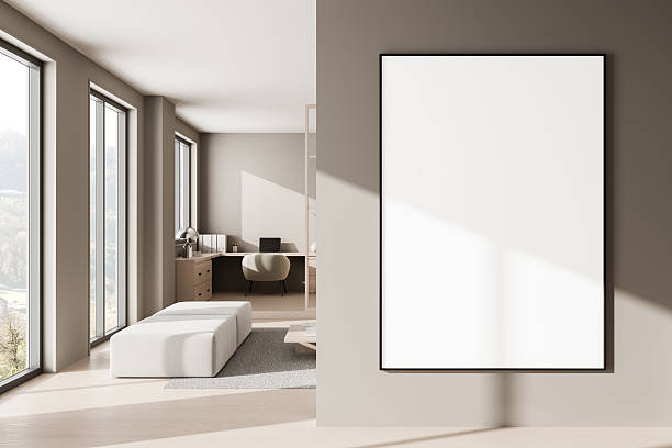 istock Blank poster mockup in modern minimalist home office interior with sunlight casting shadows on the wall and light furniture accents throughout the space. 3D Rendering 2213473978