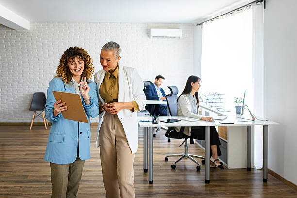 istock Two female colleagues discussing paper work while standing in a modern office 2213474766