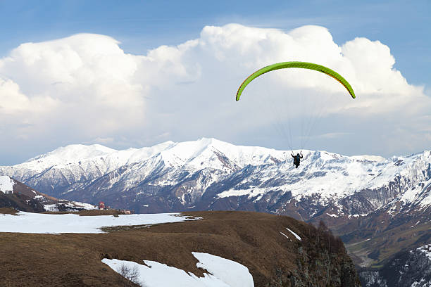A paraglider soars over the Alps.