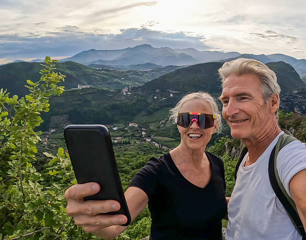 istock Mature couple take selfie on green ridge crest 2213481727