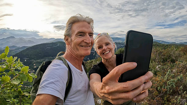 istock Mature couple take selfie on green ridge crest 2213481872
