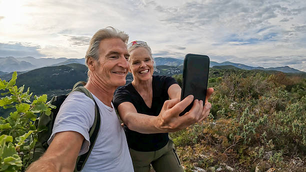 istock Mature couple take selfie on green ridge crest 2213481873