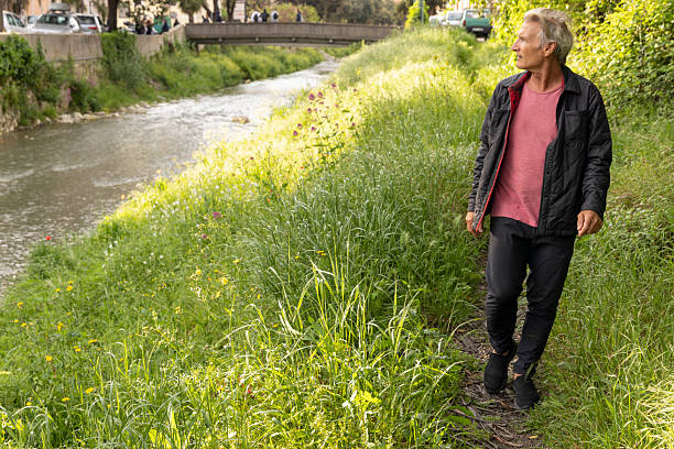 istock Mature man pauses by water's edge in springtime 2213483032