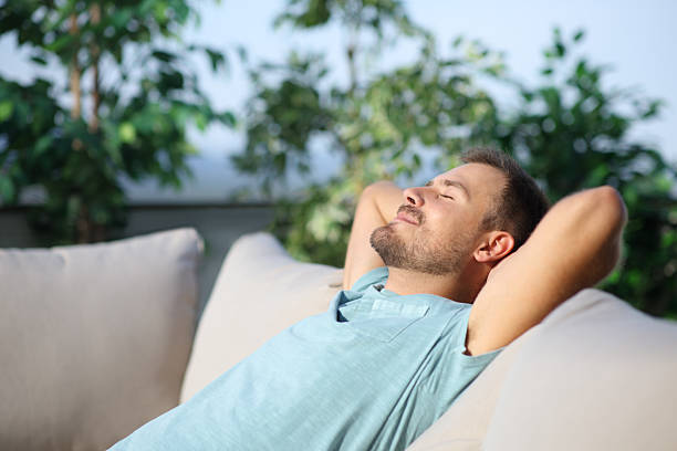 istock Man relaxing on a couch in a terrace 2213486226