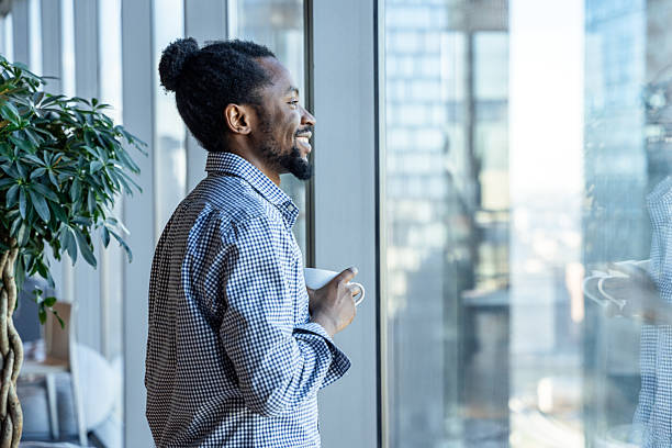 istock Smiling Professional Enjoying Coffee While Looking Out Office Window 2213495490