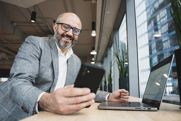 istock Professional Businessman Using Smartphone and Laptop in Modern Office Environment 2213497575