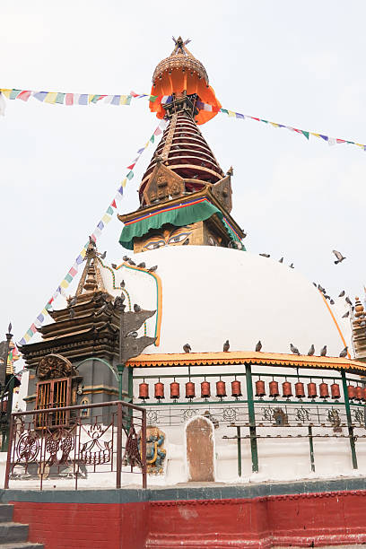 Kathesimbu Stupa in Thamel, Kathmandu, Nepal with many doves flying around the temple. Low angle photo during the day.