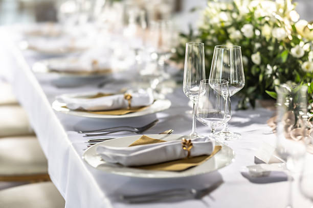 istock A wedding table covered with a white tablecloth, decorated with flowers, candles, glasses and cutlery 2213504213