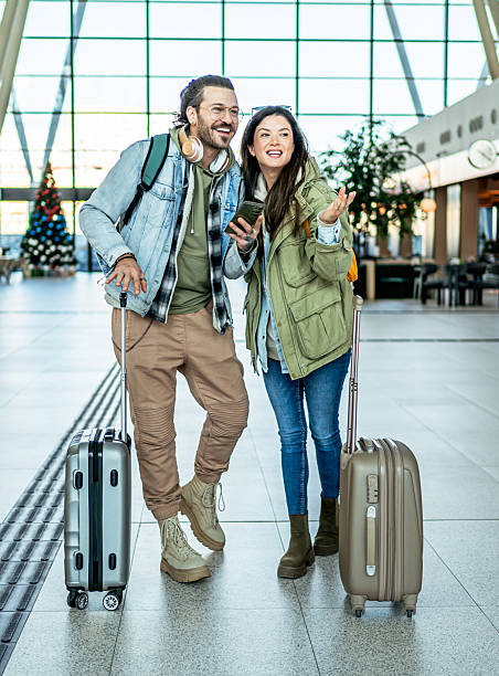 istock Tourists couple using smartphone at the airport 2213504247