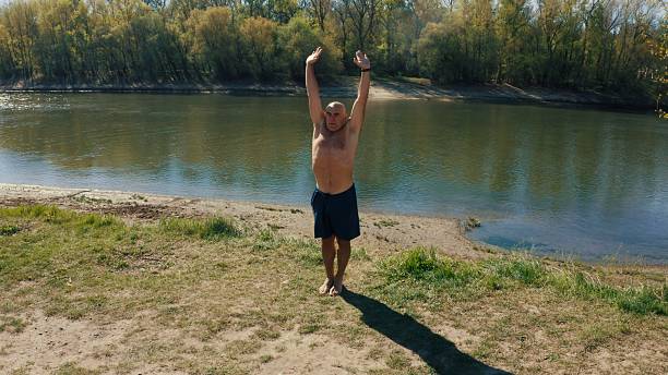 istock Mature man practicing yoga on river bank 2213504345