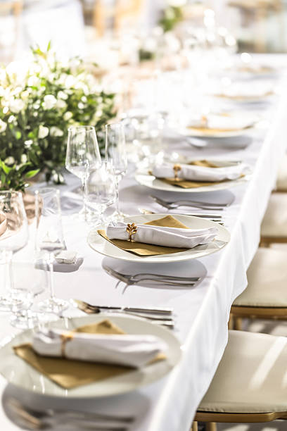 istock A wedding table covered with a white tablecloth, decorated with flowers, candles, glasses and cutlery 2213504350