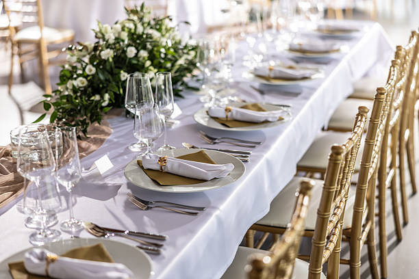 istock A wedding table covered with a white tablecloth, decorated with flowers, candles, glasses and cutlery 2213504404