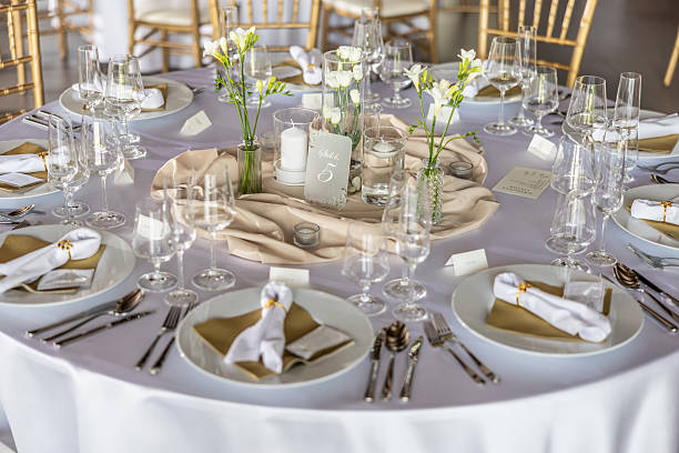 istock A wedding table covered with a white tablecloth, decorated with flowers, candles, glasses and cutlery 2213504569