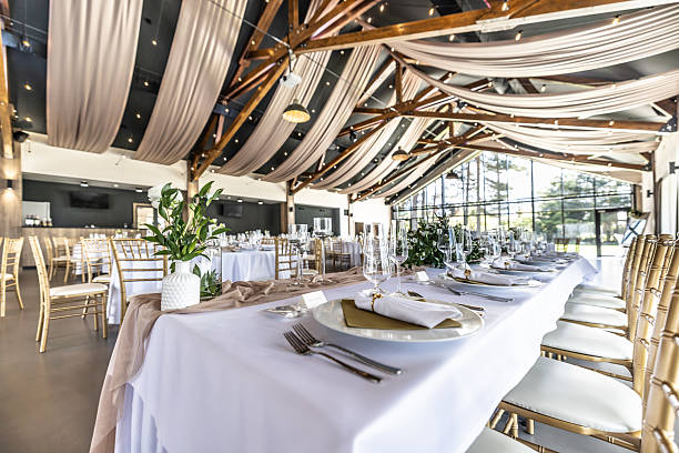 istock Wedding setting and decorated tables in a beautiful modern interior of a performance hall with a modern light ceiling of wooden construction 2213504651