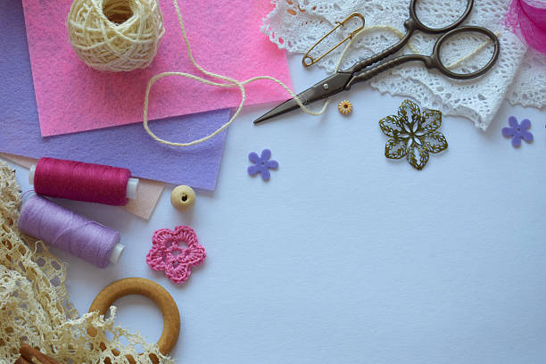 istock Bright flat lay with pink and violet threads scissors lace flowers and buttons on white background ideal for DIY handmade projects crafting and creative decor 2213504688