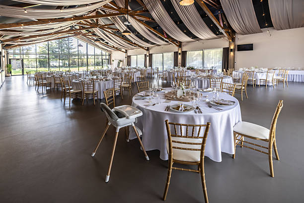 istock Wedding setting and decorated tables in a beautiful modern interior of a performance hall with a modern light ceiling of wooden construction 2213505040