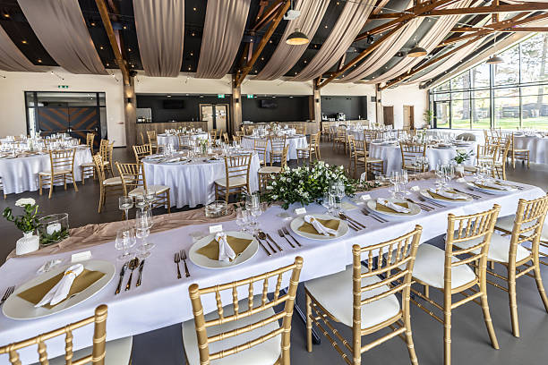 istock Wedding setting and decorated tables in a beautiful modern interior of a performance hall with a modern light ceiling of wooden construction 2213505104