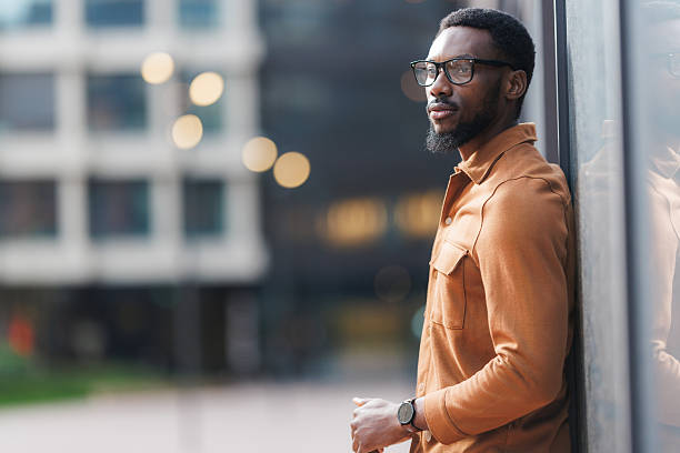 istock Modern young man leaning on glass wall in urban setting 2213505409