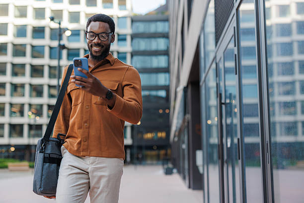 Man walking outside using his phone in a business area