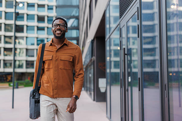 istock Confident businessman walking outside a modern office building area 2213505551