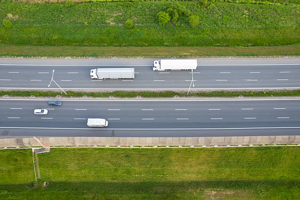 istock Traffic moves along a busy highway lined with green fields and trees on a clear day showcasing various vehicles in transit 2213505880
