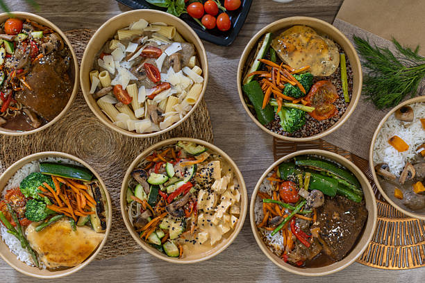 istock Assorted healthy takeaway bowls with vegetables, pasta and sauces on rustic table 2213509746