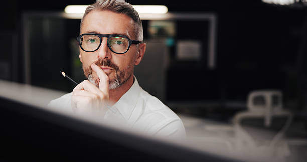 istock Office, mature businessman and architect with thinking for drawing board, creative solution and idea. Night, male person and designer with pencil for sketch, planning and problem solving with review 2213509914