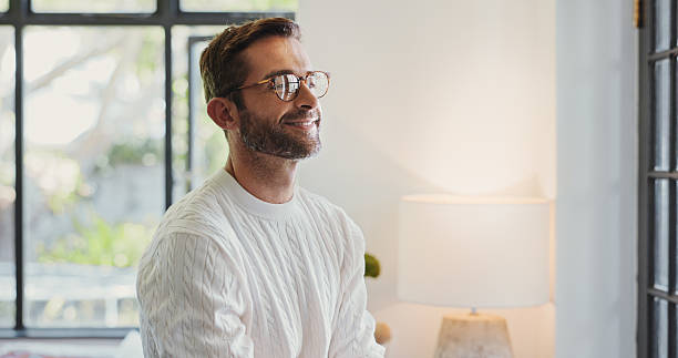 istock Home, man and thinking with smile for relax, comfortable and confidence with thoughts on weekend. House, male person and happiness with inspiration for wellness, stress free and peace in morning 2213514418