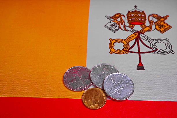 Different denominations of money on the background of the Vatican flag.