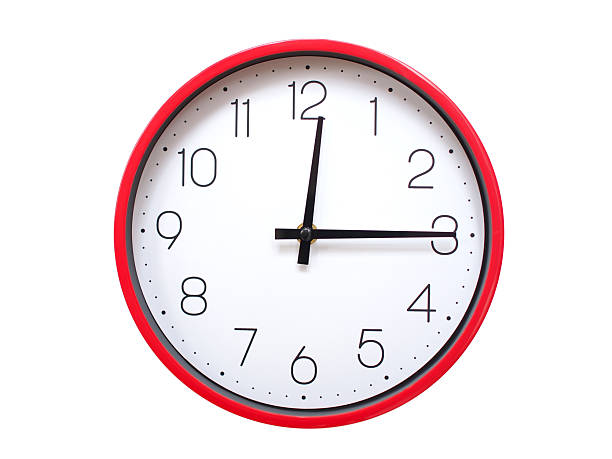 Round wall clock with black frame showing time at 00:15 or 12:15. Ideal for concepts of time or scheduling.
