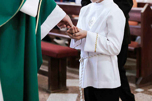 Priest distributing Holy Communion to the faithful during Catholic mass, symbolizing the sacred sacrament and deep spiritual devotion.
