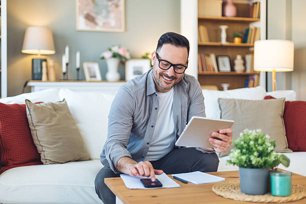 istock Mid adult man working from home on digital tablet 2213529490