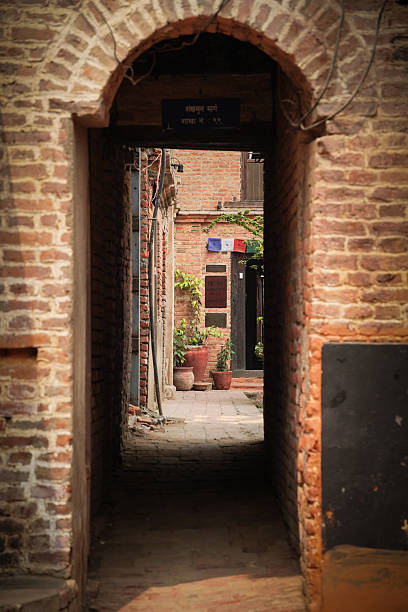 Kathmandu, Nepal - April 1, 2025: A dark alley in nepalese building with exposed brick wall.
