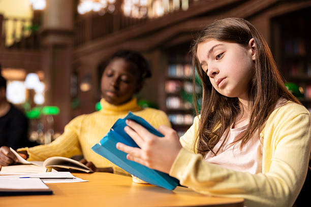 istock Preteen students focus on reading the required books at a study desk 2213534015