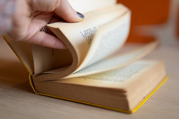 istock Hand flicking pages of a book 2213536898
